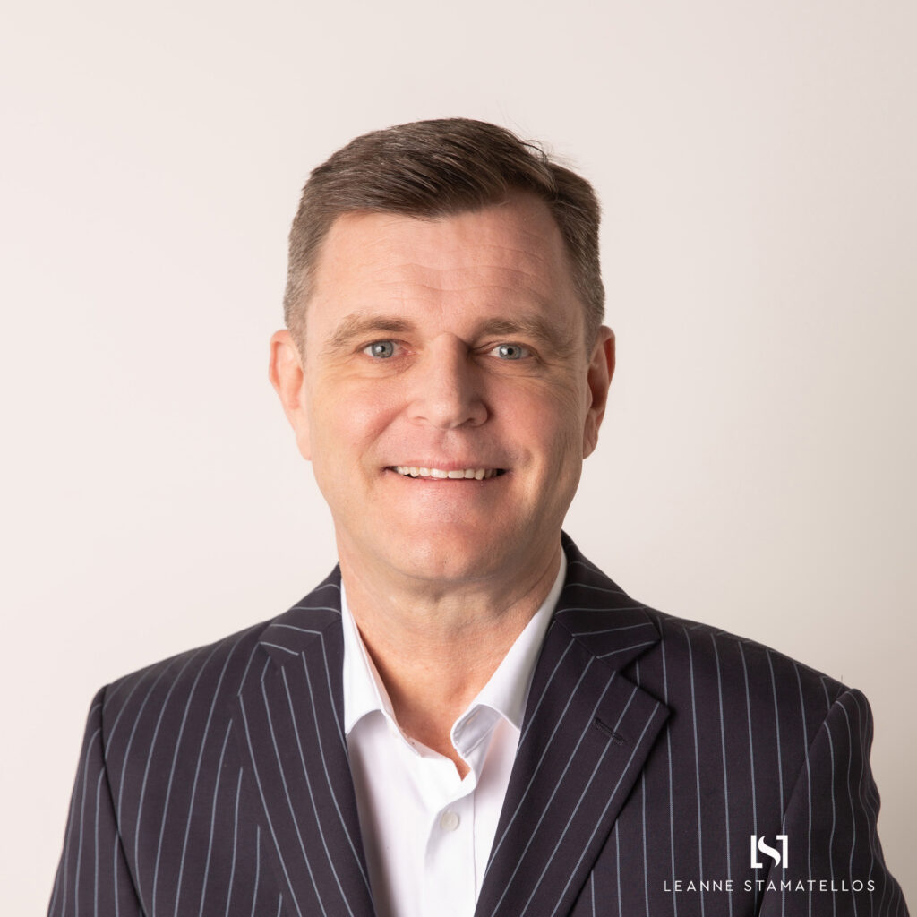 headshot of a man with a pinstripe jacket