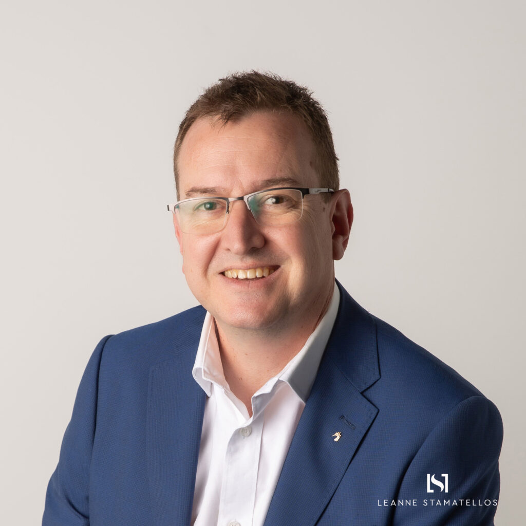 headshot of a man with glasses